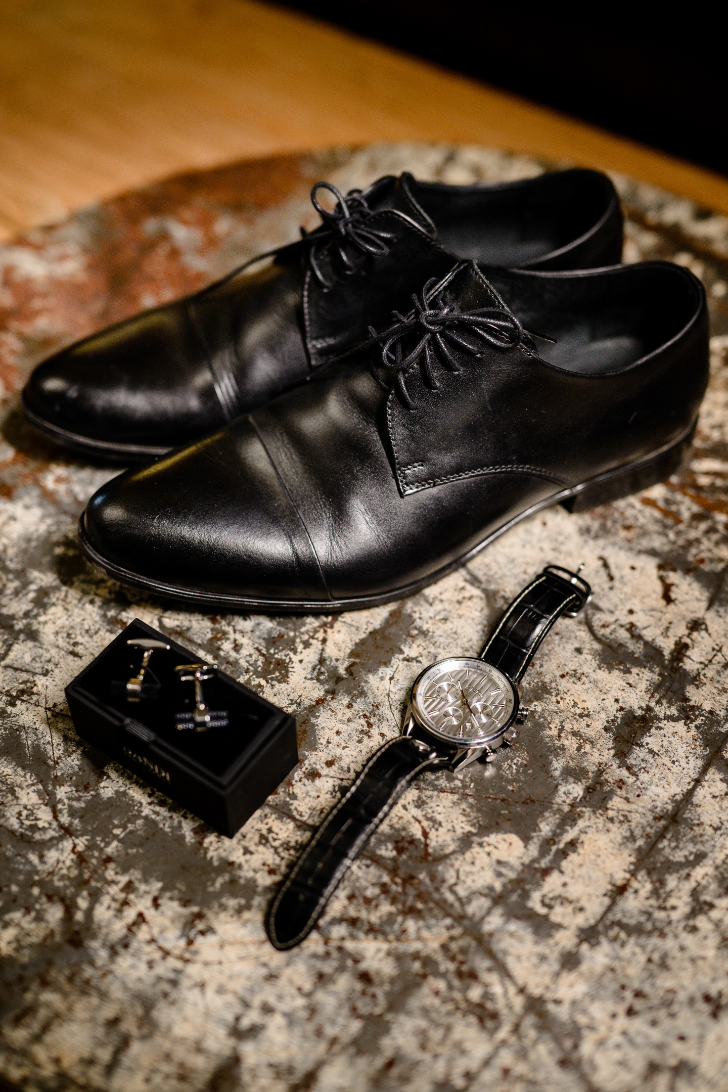 ženichovy manžetové knoflíčky spolu s hodinkami a botami