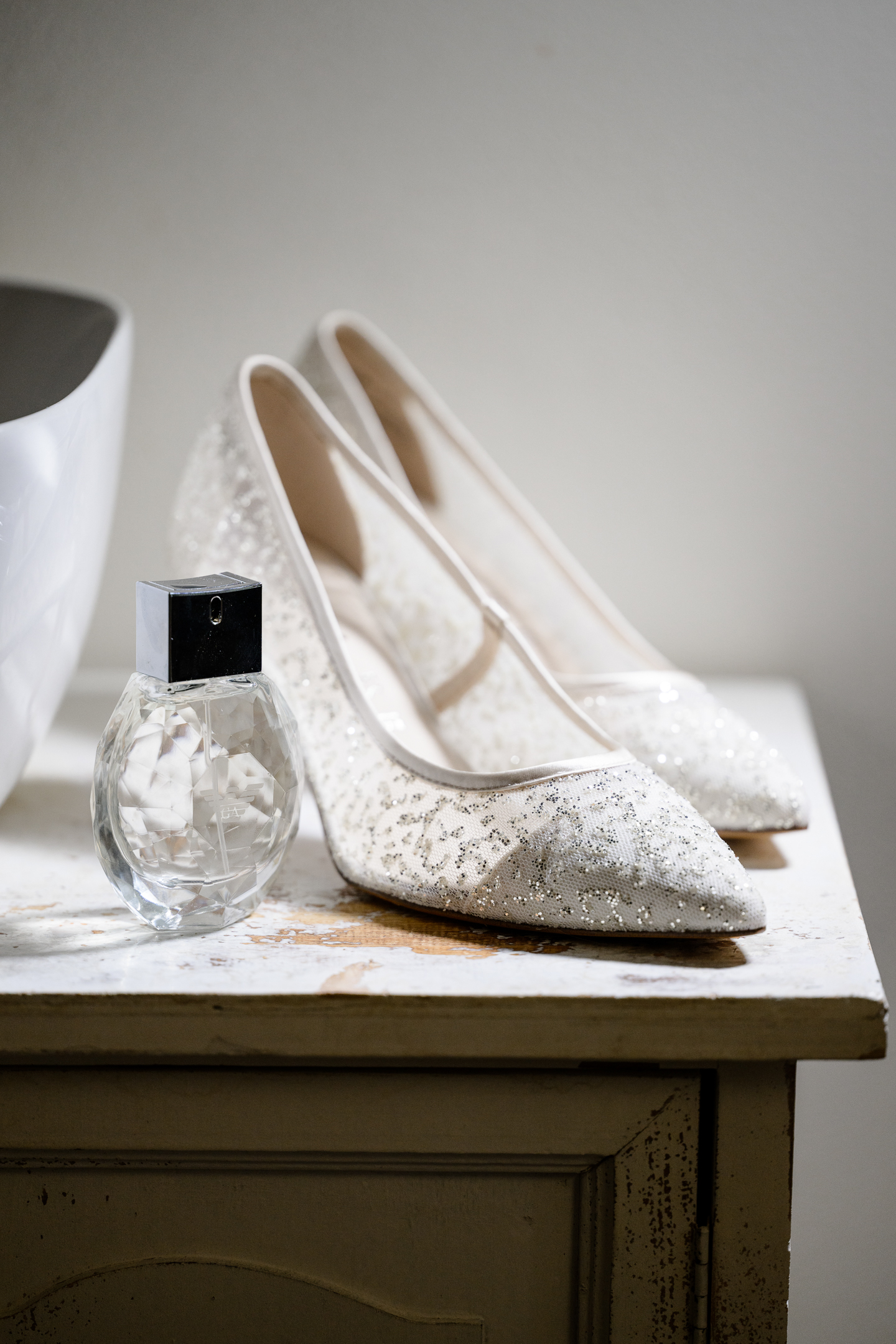 boty a parfém na pokoji kde probíhají přípravy nevěsty